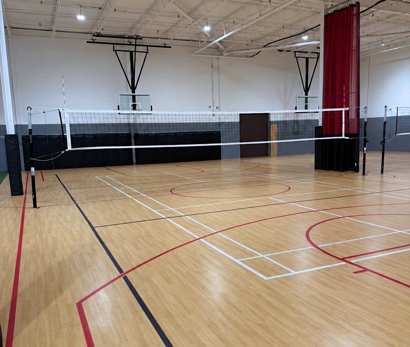 Pakmen Courts South playing space with a volleyball net, basketball markings and hoops.
